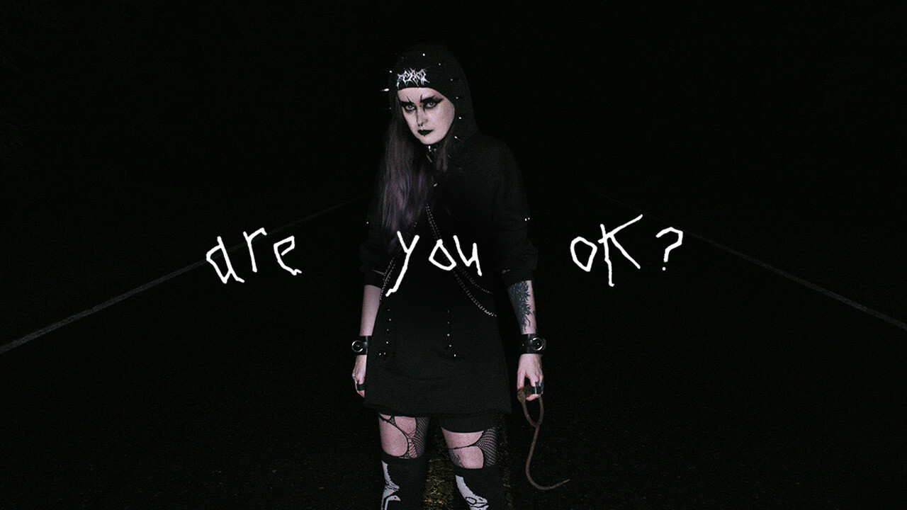 non-binary goth stands in the middle of a rural road at night with a meathook in one hand. scrawled over the image are the words "are you ok?" non-binary goth stands in the middle of a rural road at night with a meathook in one hand. scrawled over the image are the words "are you ok?"